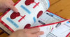 A person flipping through a spiral bound book with illustrations